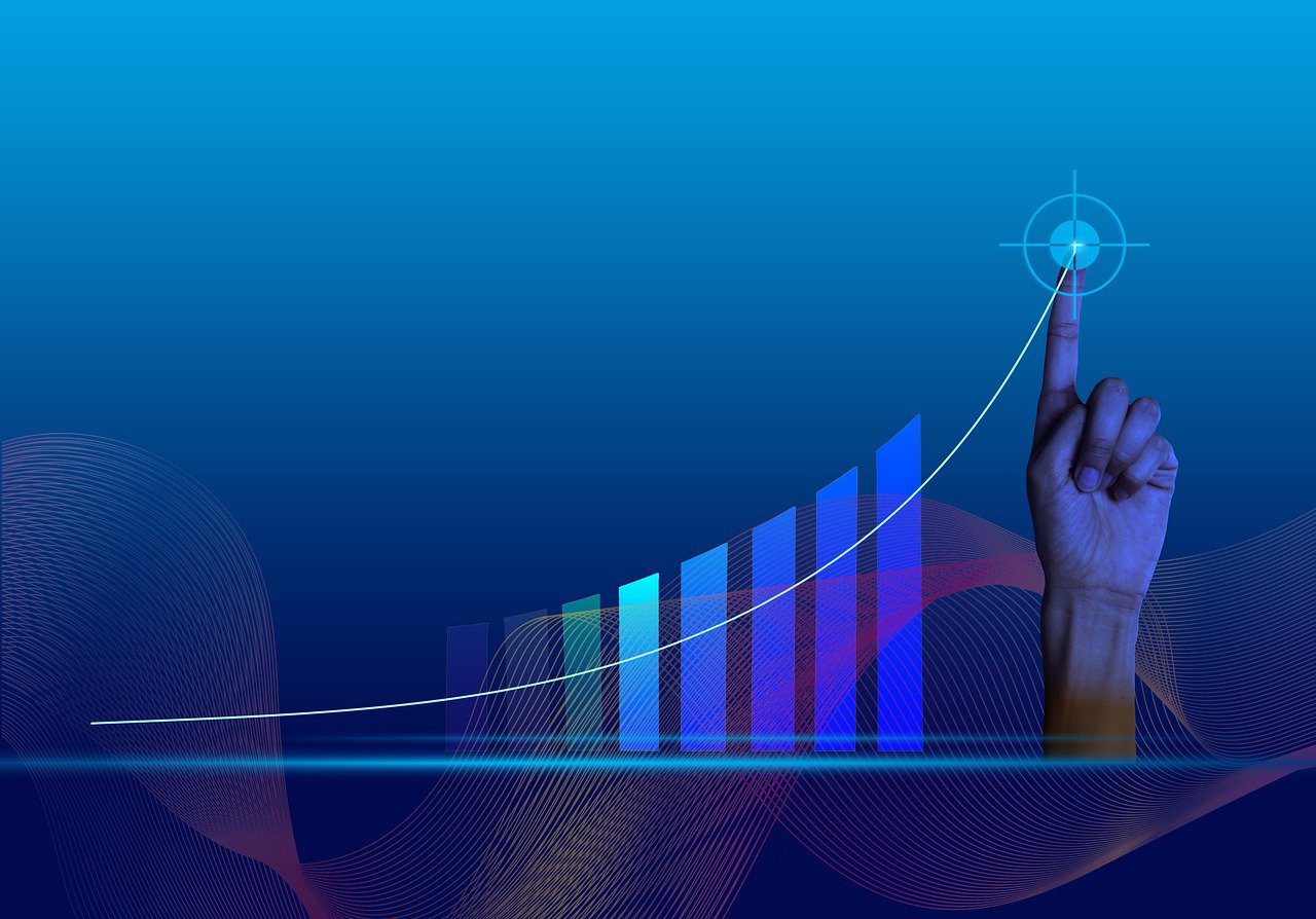 A digital chart trending upward with a hand pointing to a target at the top of the tallest bar on the chart.