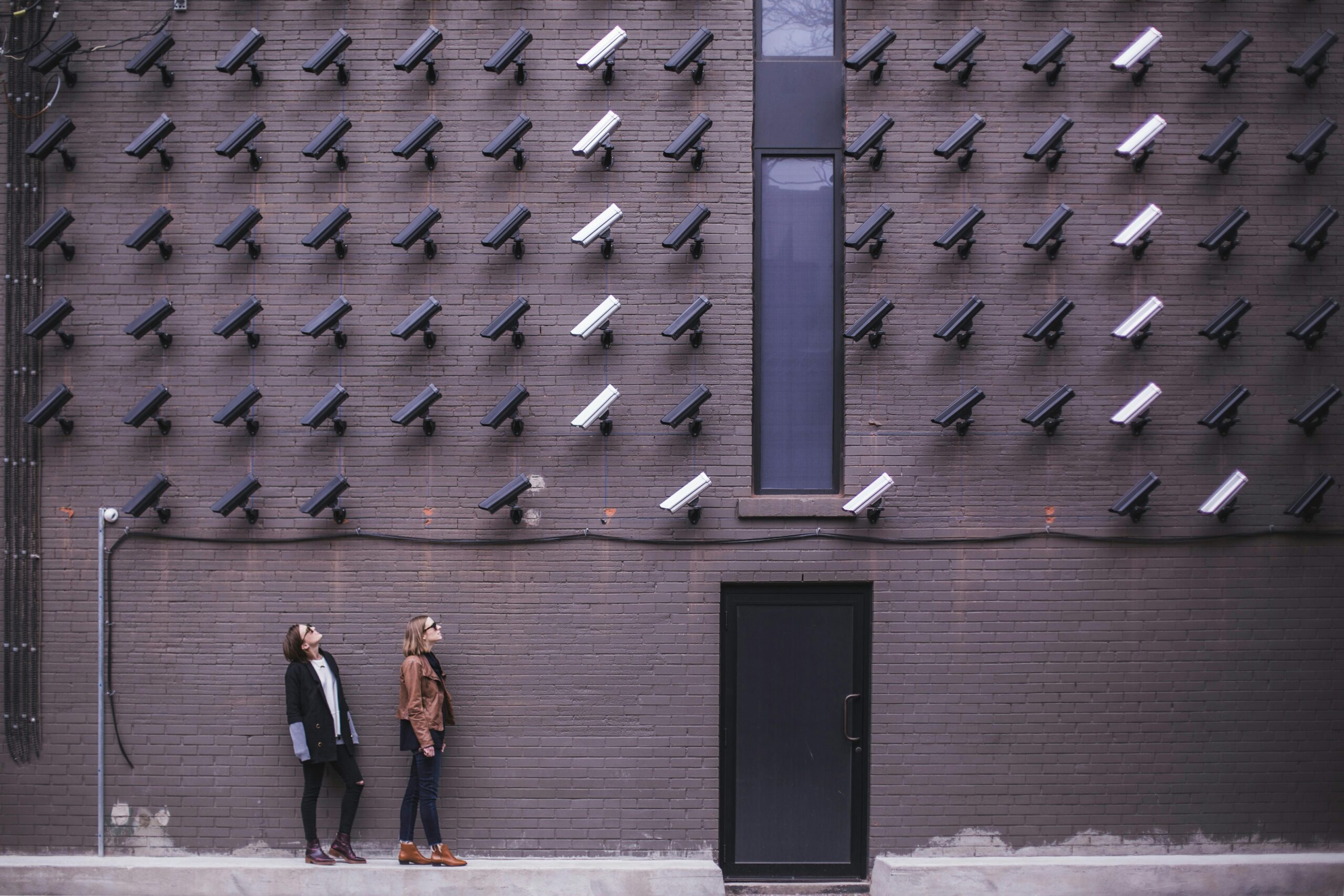 A wall of CCTV cameras all aiming at one target 