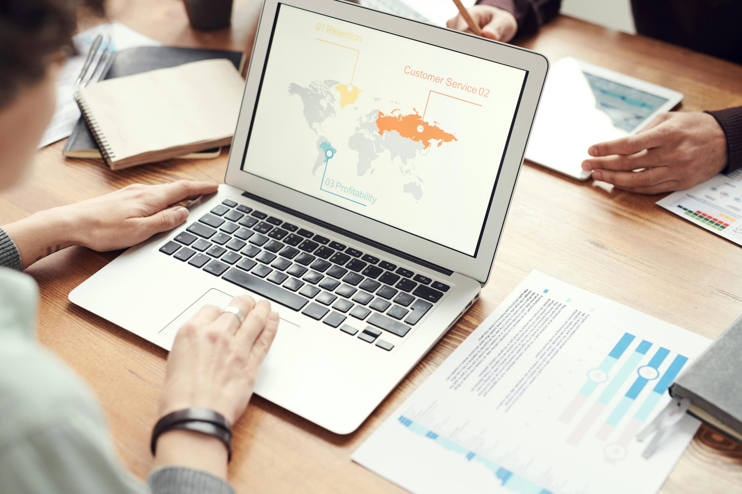 A laptop screen displaying a world map with different KPIS of each region